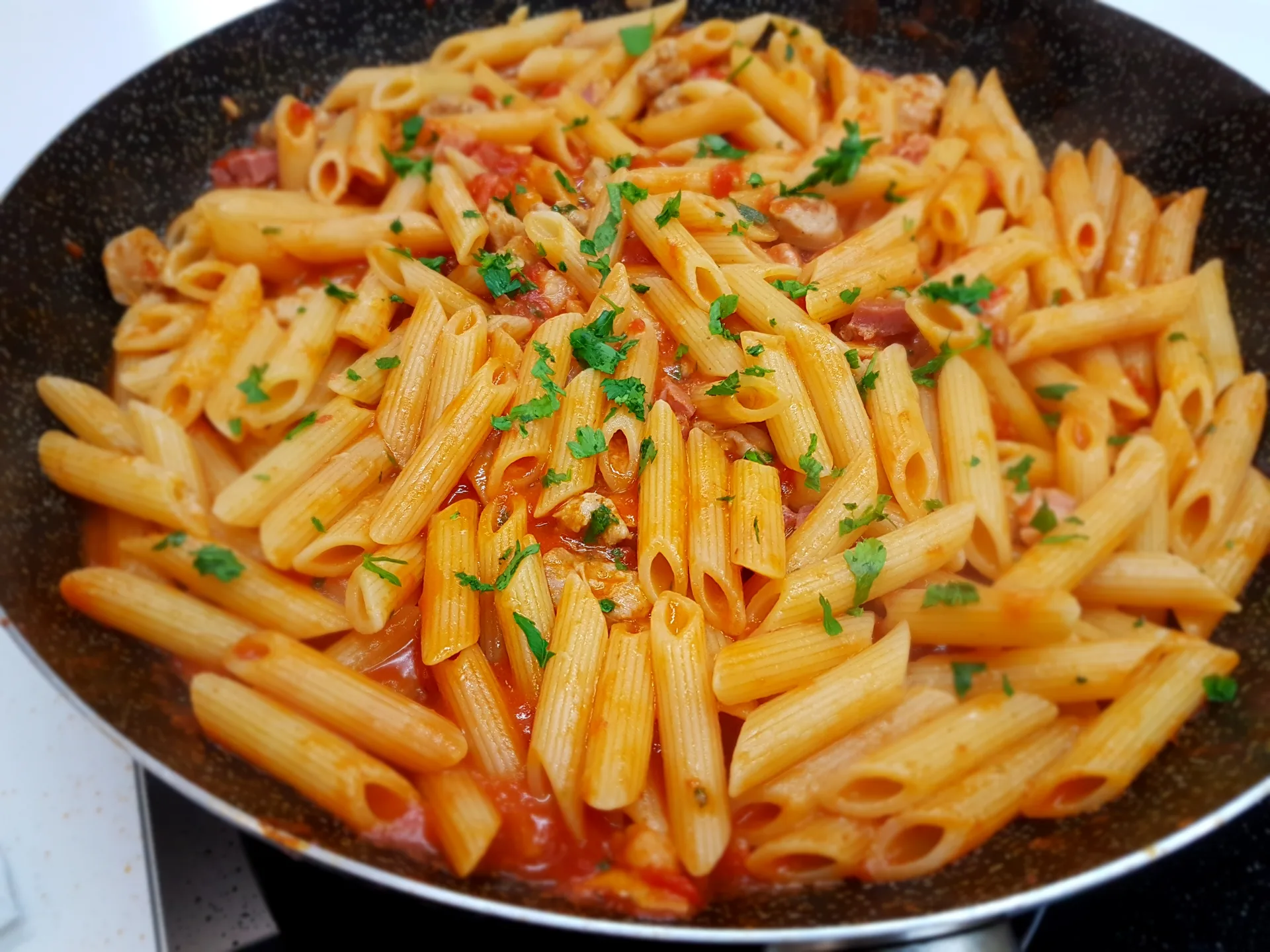 Penne all'arrabbiata con salsiccia e pancetta